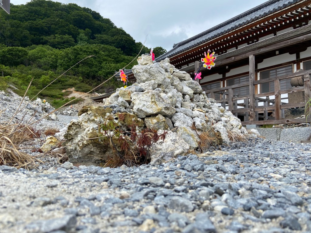 Gravel mound with windmills at Osorezan, symbolizing unborn children stacking stones in the Buddhist afterlife.